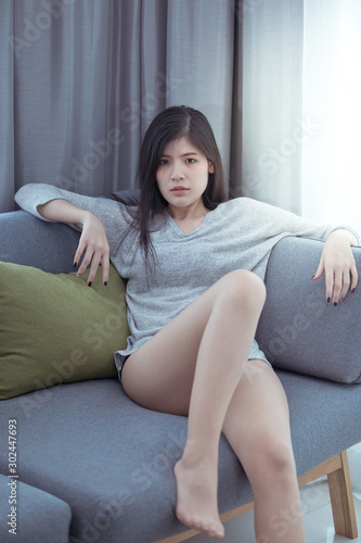 Beautiful woman lying on the sofa with the light by the window