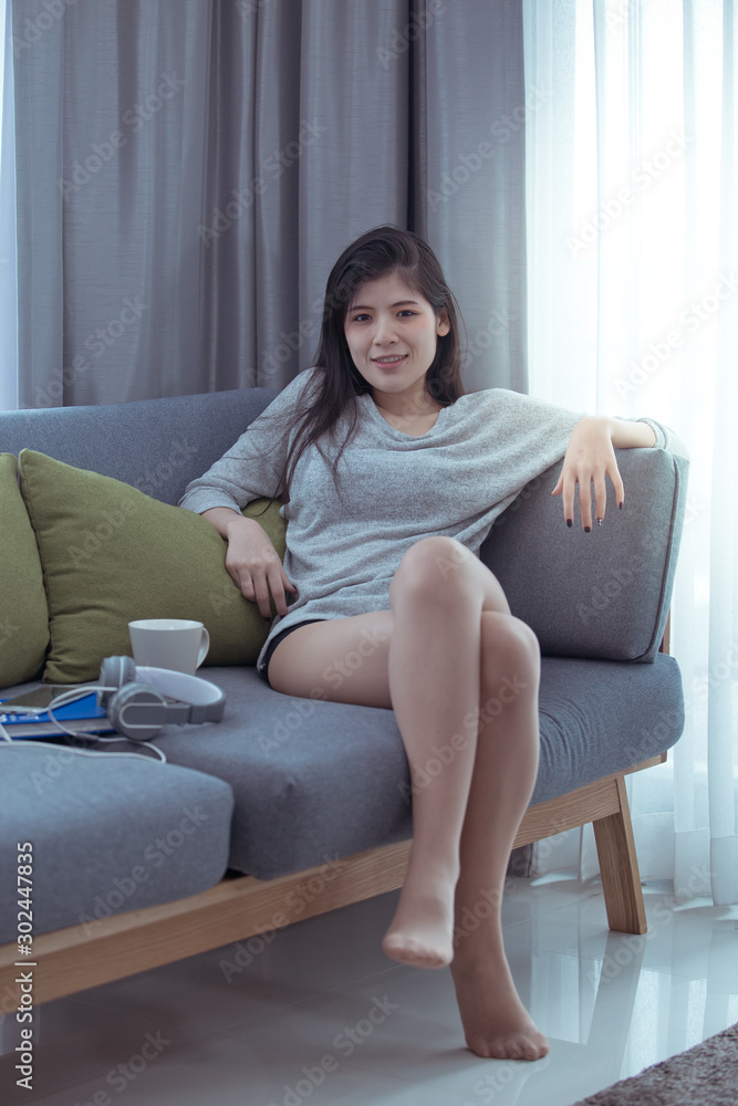 Beautiful woman lying on the sofa with the light by the window Beautiful woman lying on the sofa with the light by the window