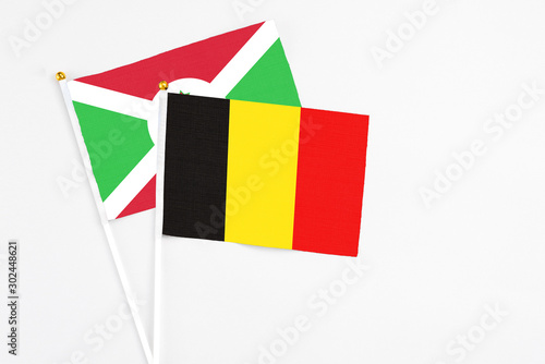 Belgium and Burundi stick flags on white background. High quality fabric, miniature national flag. Peaceful global concept.White floor for copy space.