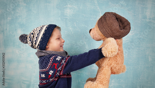 niedlicher Junge kuschelt mit Teddy photo