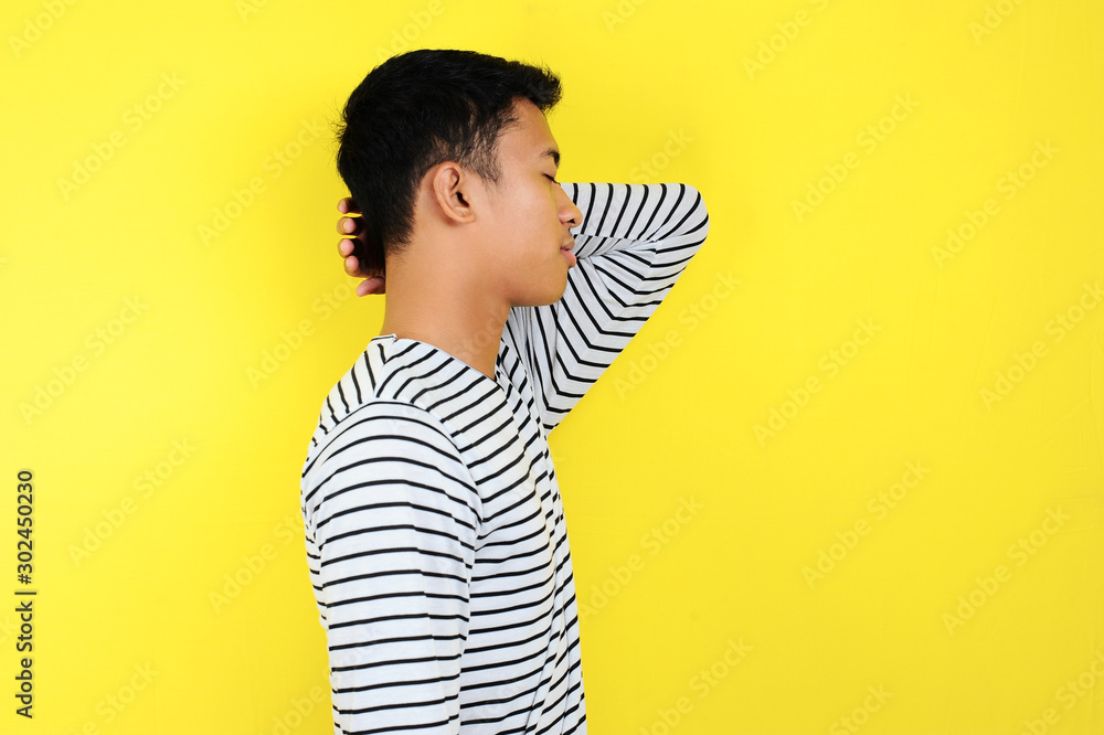 Businessman standing and doing a sleep gesture. Portrait of young Asian businessman standing and doing a sleep gesture Businessman standing and doing a sleep gesture. Portrait of young Asian businessman standing and doing a sleep gesture