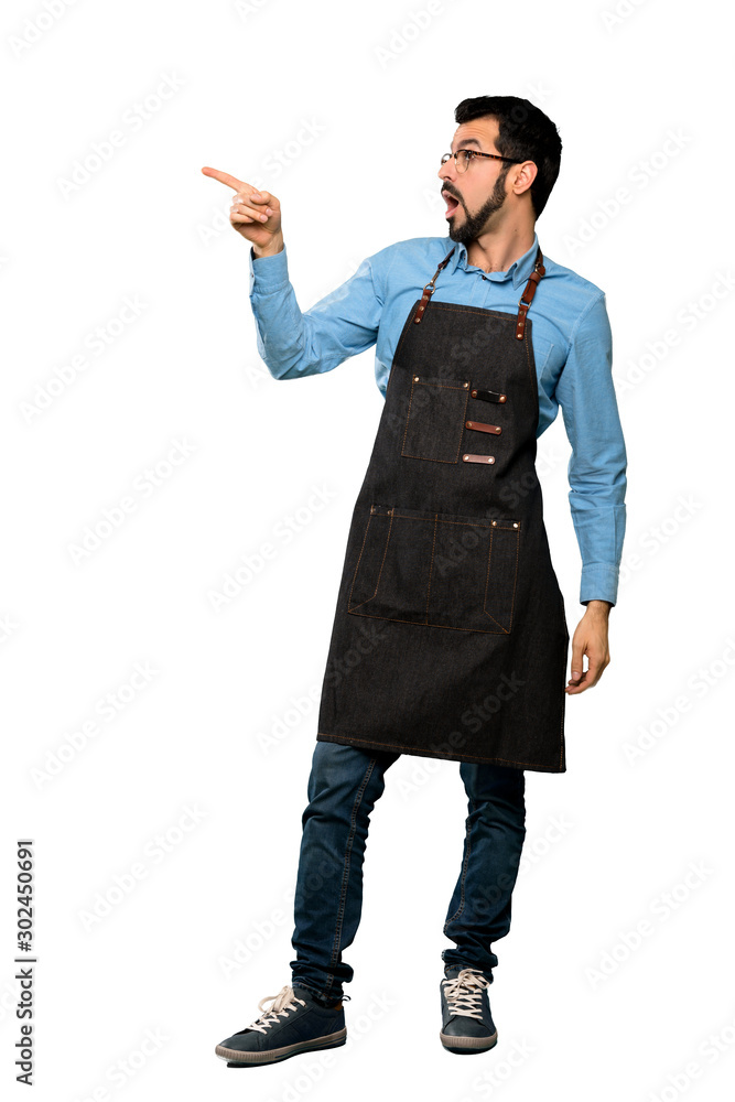 Full-length shot of Man with apron pointing away over isolated white background Full-length shot of Man with apron pointing away over isolated white background