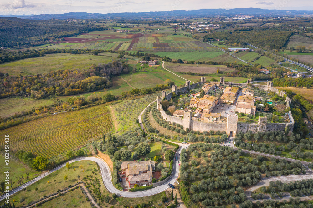 aerial view to curved road and medieval castle Monteriggioni in Tuscany in Italy from drone