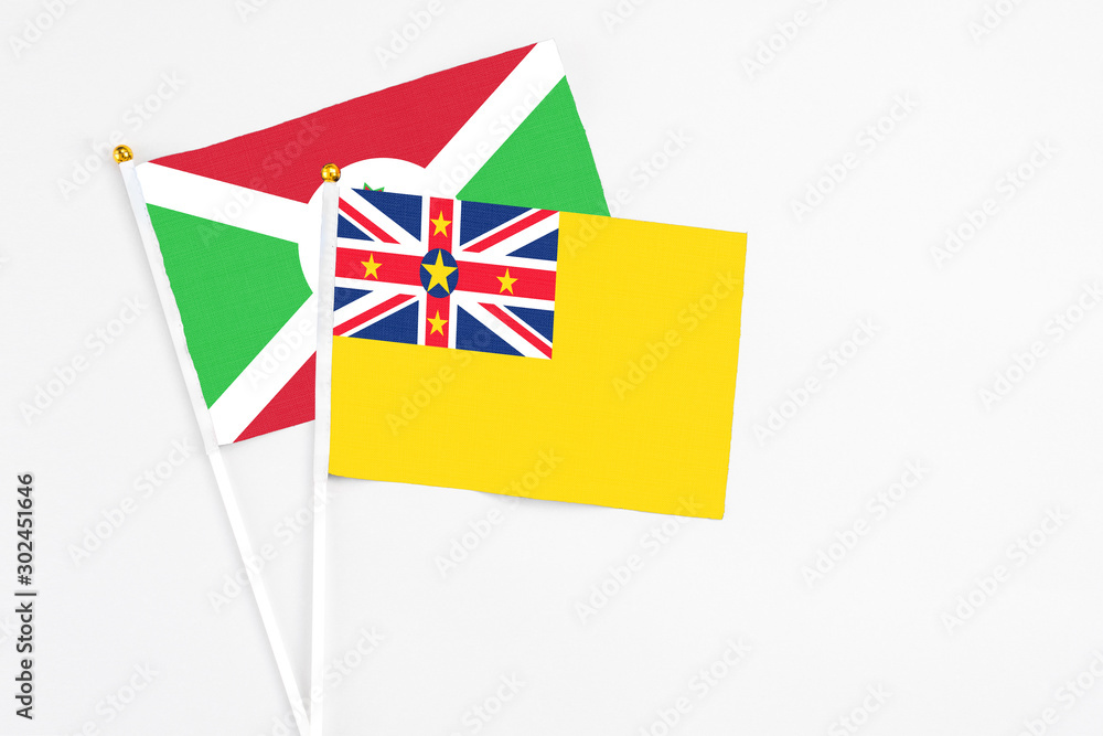 Niue and Burundi stick flags on white background. High quality fabric, miniature national flag. Peaceful global concept.White floor for copy space. Niue and Burundi stick flags on white background. High quality fabric, miniature national flag. Peaceful global concept.White floor for copy space.