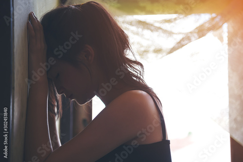 Sad depressed woman suffering from family life. women sitting in dark room cryng, palm close her face. Young beautiful women thinking how to solve problem. photo