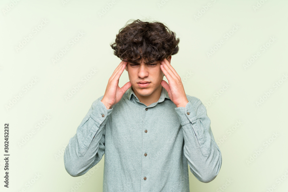 Young man over isolated green wall unhappy and frustrated with something. Negative facial expression Young man over isolated green wall unhappy and frustrated with something. Negative facial expression