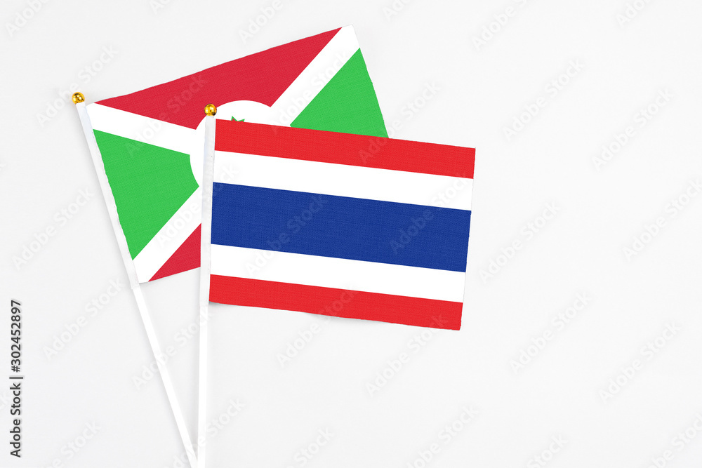 Thailand and Burundi stick flags on white background. High quality fabric, miniature national flag. Peaceful global concept.White floor for copy space.