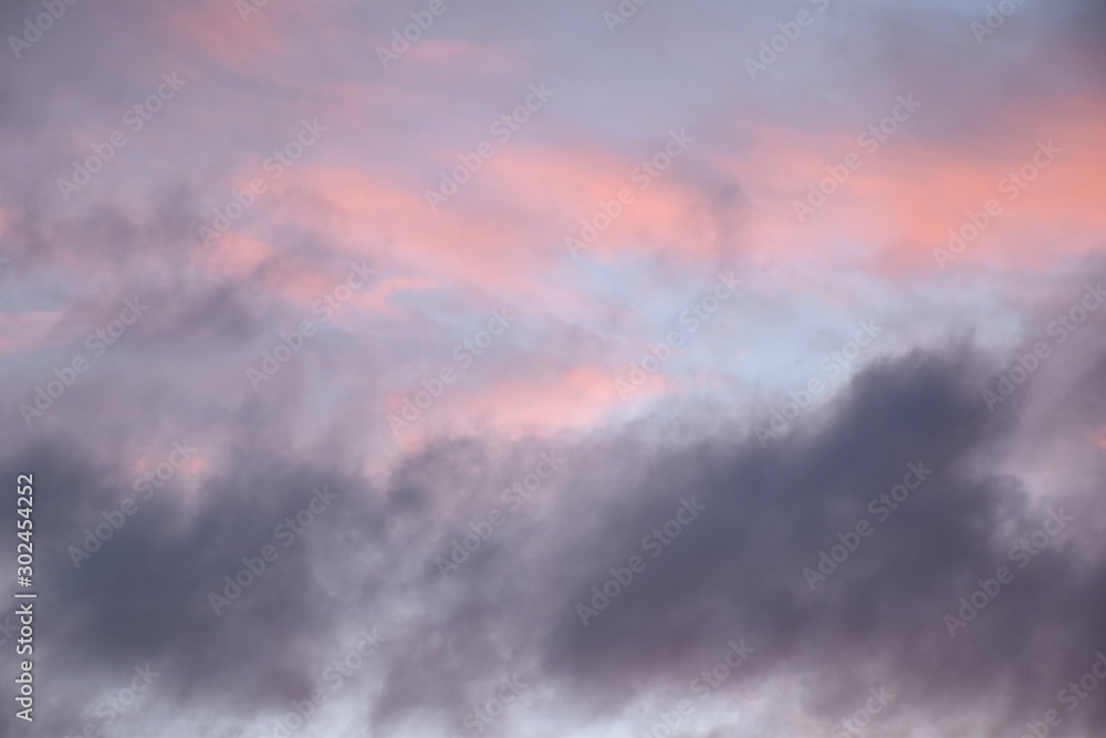 hellrosa und dunkellila Wolken am hellblauen Abendhimmel