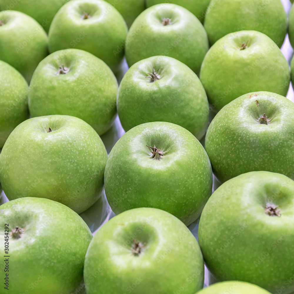 The ripe green apples stacked in a row The ripe green apples stacked in a row