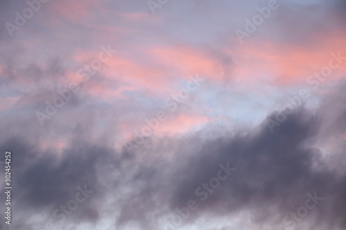 hellrosa und dunkellila Wolken am hellblauen Abendhimmel