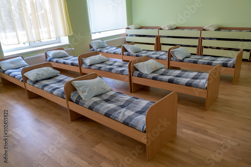 Many small beds in daycare preeschool empty bedroom. © bilanol