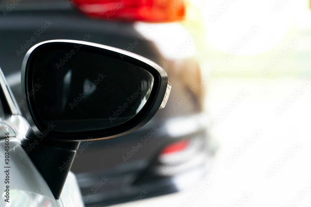 The side mirror of the car that is parked in the parking place and the vehicle crosses. The side mirror of the car that is parked in the parking place and the vehicle crosses.