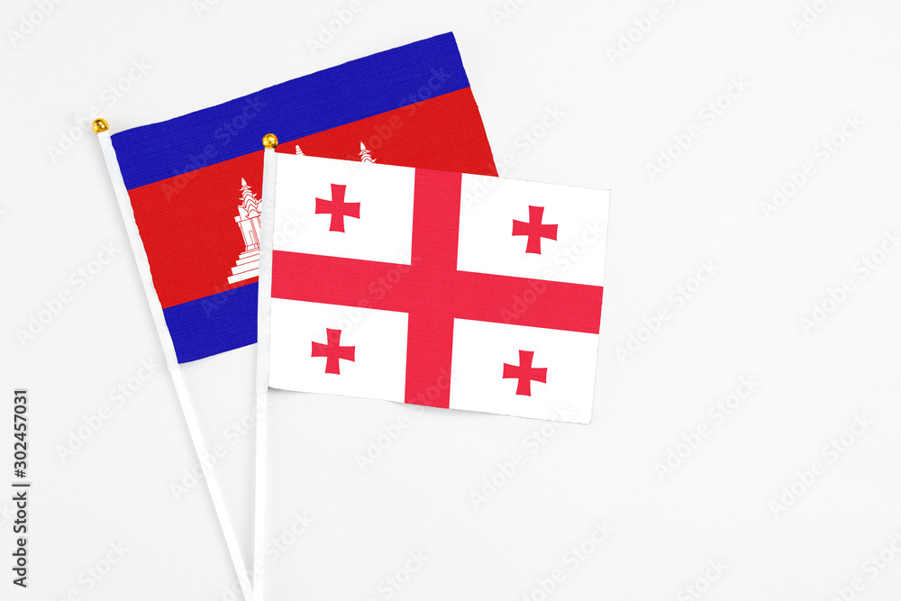 Georgia and Cambodia stick flags on white background. High quality fabric, miniature national flag. Peaceful global concept.White floor for copy space.