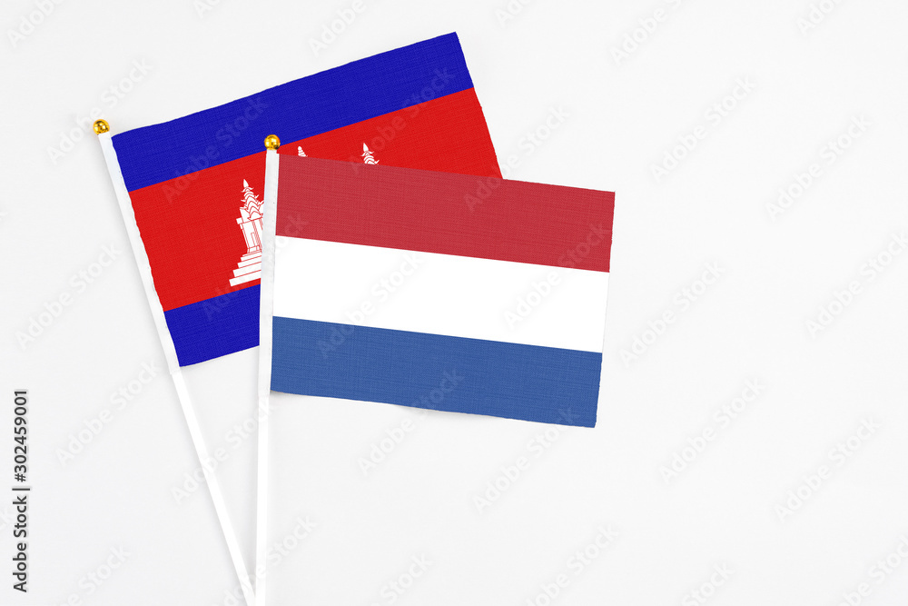 Netherlands and Cambodia stick flags on white background. High quality fabric, miniature national flag. Peaceful global concept.White floor for copy space.