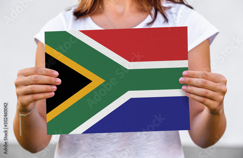 woman holds flag of South Africa on paper sheet