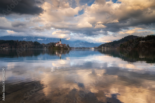 Amazing colorful view of Bled lake with St. Marys Church of the Assumption on the small island and mountains in the background at sunset © Jess_Ivanova