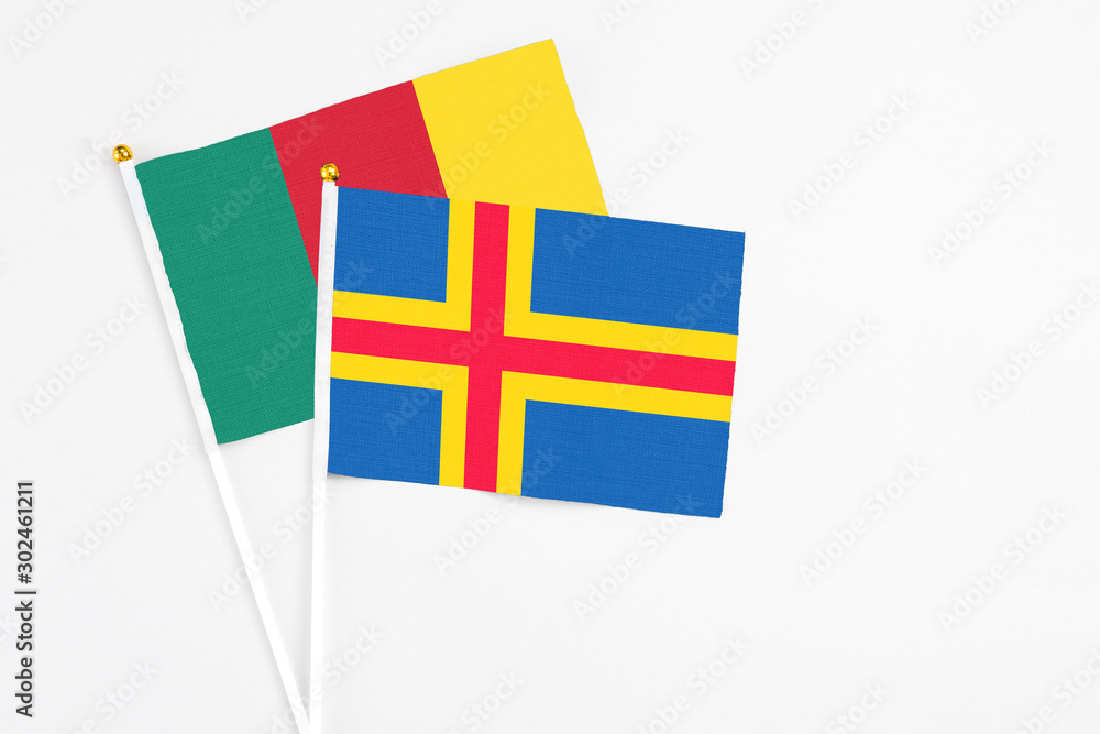 Aland Islands and Cameroon stick flags on white background. High quality fabric, miniature national flag. Peaceful global concept.White floor for copy space. Aland Islands and Cameroon stick flags on white background. High quality fabric, miniature national flag. Peaceful global concept.White floor for copy space.