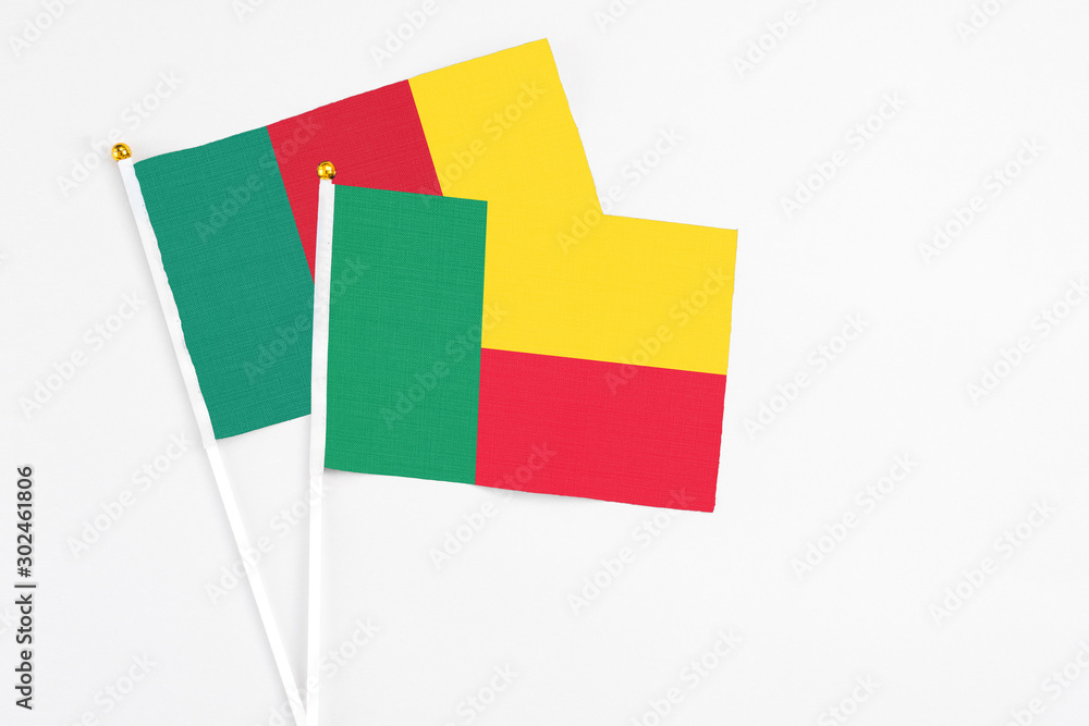 Benin and Cameroon stick flags on white background. High quality fabric, miniature national flag. Peaceful global concept.White floor for copy space. Benin and Cameroon stick flags on white background. High quality fabric, miniature national flag. Peaceful global concept.White floor for copy space.