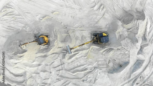 Aerial view, Two excavators are working in a sand pit. Extraction of sand. Work of two yellow excavators View from the top