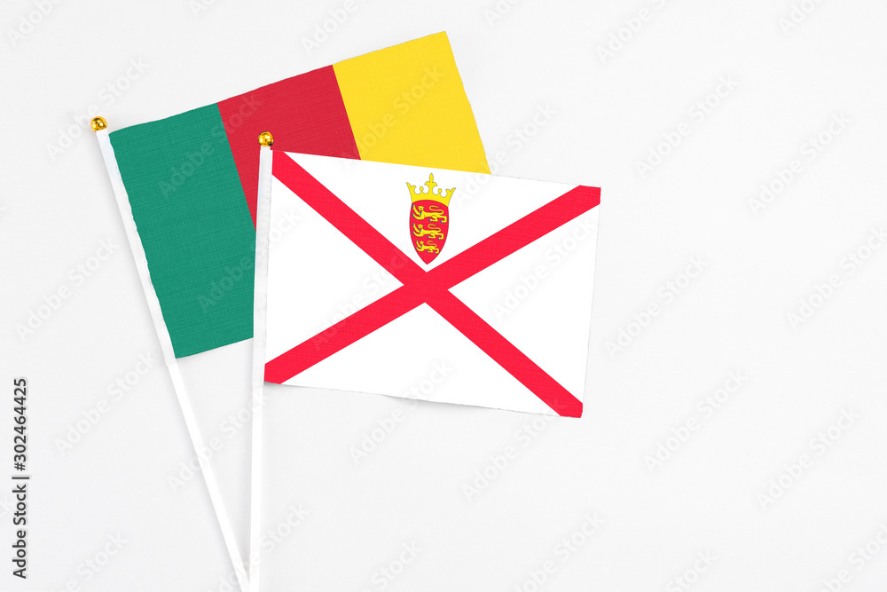 Jersey and Cameroon stick flags on white background. High quality fabric, miniature national flag. Peaceful global concept.White floor for copy space. Jersey and Cameroon stick flags on white background. High quality fabric, miniature national flag. Peaceful global concept.White floor for copy space.