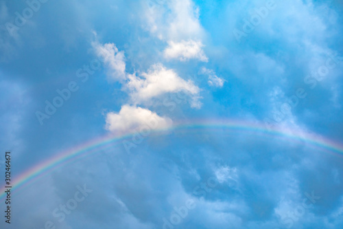 Rainbow on a blue sky on a beautiful summer day © Sergei Malkov