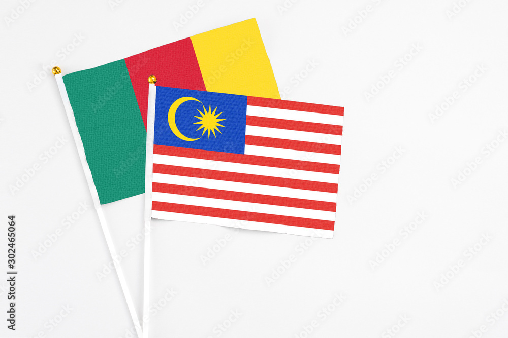 Malaysia and Cameroon stick flags on white background. High quality fabric, miniature national flag. Peaceful global concept.White floor for copy space. Malaysia and Cameroon stick flags on white background. High quality fabric, miniature national flag. Peaceful global concept.White floor for copy space.