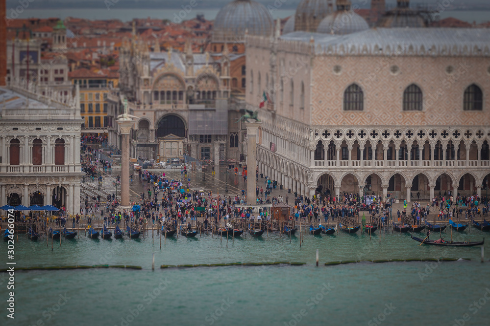 Tilt shift effect of gondolas and people in San Marco square during high water, Venice, Italy