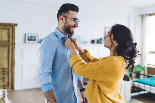 Wife helping husband to button up