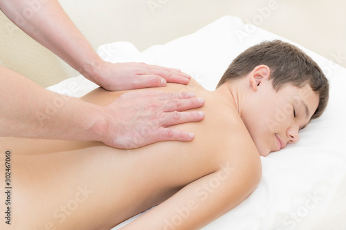 Medical sports massage of the feet of a boy in a massage room on a white background.