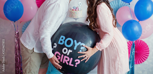 Obraz na plátne man and woman holding black balloon with boy or girl? on gender reveal party