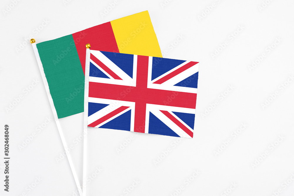 United Kingdom and Cameroon stick flags on white background. High quality fabric, miniature national flag. Peaceful global concept.White floor for copy space. United Kingdom and Cameroon stick flags on white background. High quality fabric, miniature national flag. Peaceful global concept.White floor for copy space.
