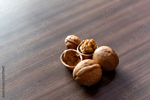Walnuts kernels on wooden desk with color background, Whole walnut in wood vintage bowl.