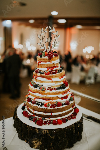 wedding cake decorated with berries and flowers