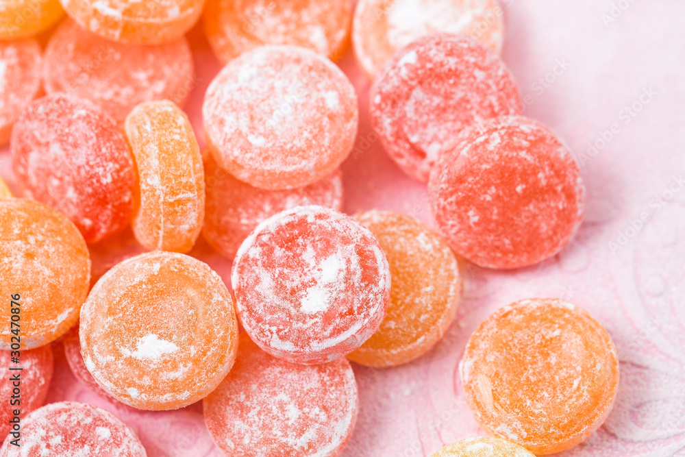 Fruit candy scattered on a pink background, candy in powdered sugar Fruit candy scattered on a pink background, candy in powdered sugar