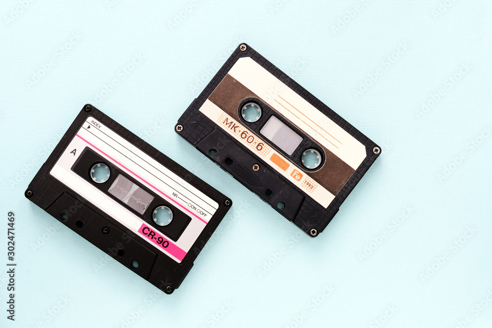 Fototapeta premium Two vintage audio tapes on a light blue background close-up. Top view