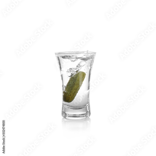 Russian vodka with pickle in shot glass isolated on white