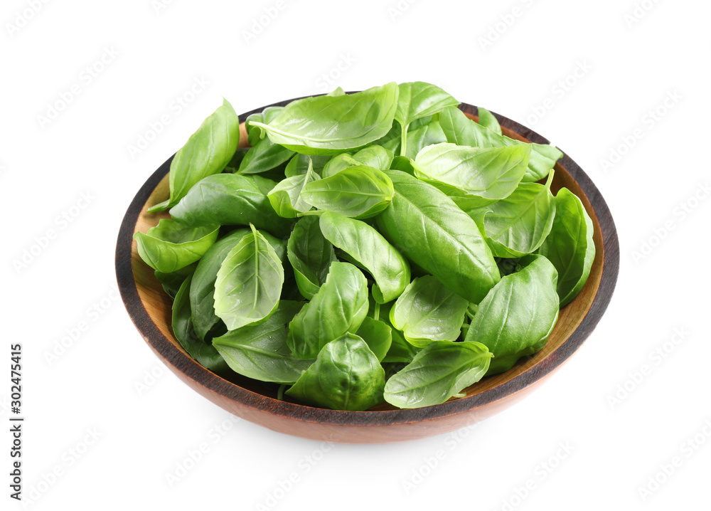 Fresh basil leaves in wooden bowl isolated on white Fresh basil leaves in wooden bowl isolated on white