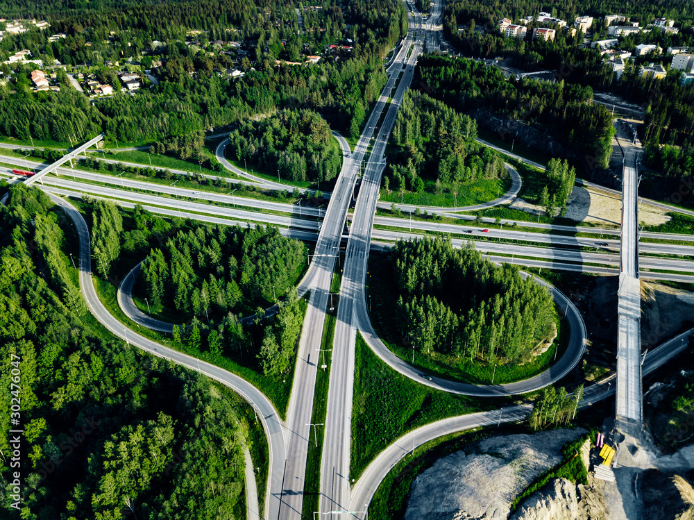 Aerial top view of Highway and overpass with green forests in Finland.