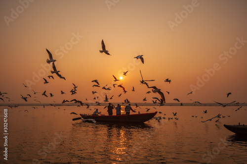Varanasi, Banaras, Uttar Pradesh, India - January 31, 2011: Boats and Migratory Seagull birds at sunrise on the Ganga, in the holy city of Varanasi, India