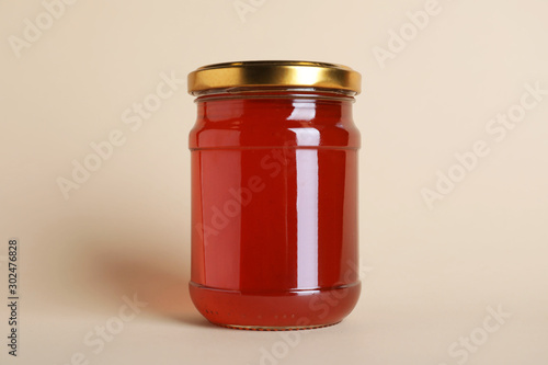 Jar of organic honey on beige background