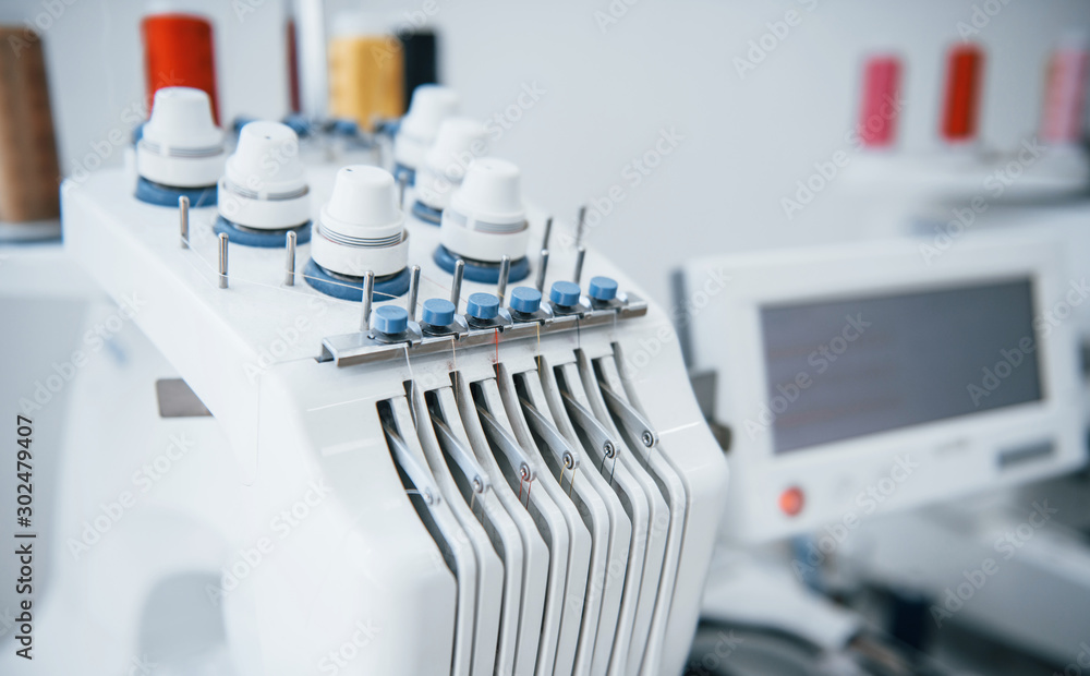 Close up view of white automatic sewing machine at factory