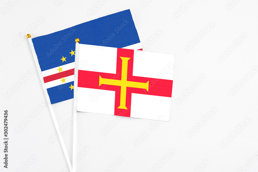 Guernsey and Cape Verde stick flags on white background. High quality fabric, miniature national flag. Peaceful global concept.White floor for copy space.