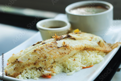 Grilled Pangasius Fillet with rice and mashed potatoes on white plate served with seafood sauce