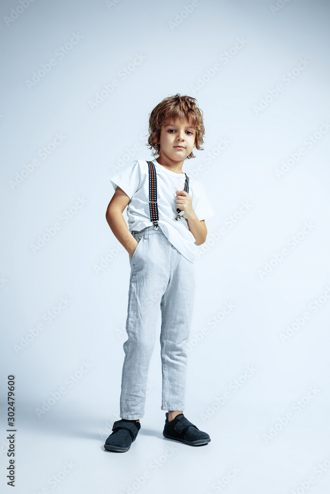 Pretty young boy in casual clothes on white studio background. Fashionable posing, looks confident. Caucasian male preschooler with bright facial emotions. Childhood, expression, having fun. Pretty young boy in casual clothes on white studio background. Fashionable posing, looks confident. Caucasian male preschooler with bright facial emotions. Childhood, expression, having fun.
