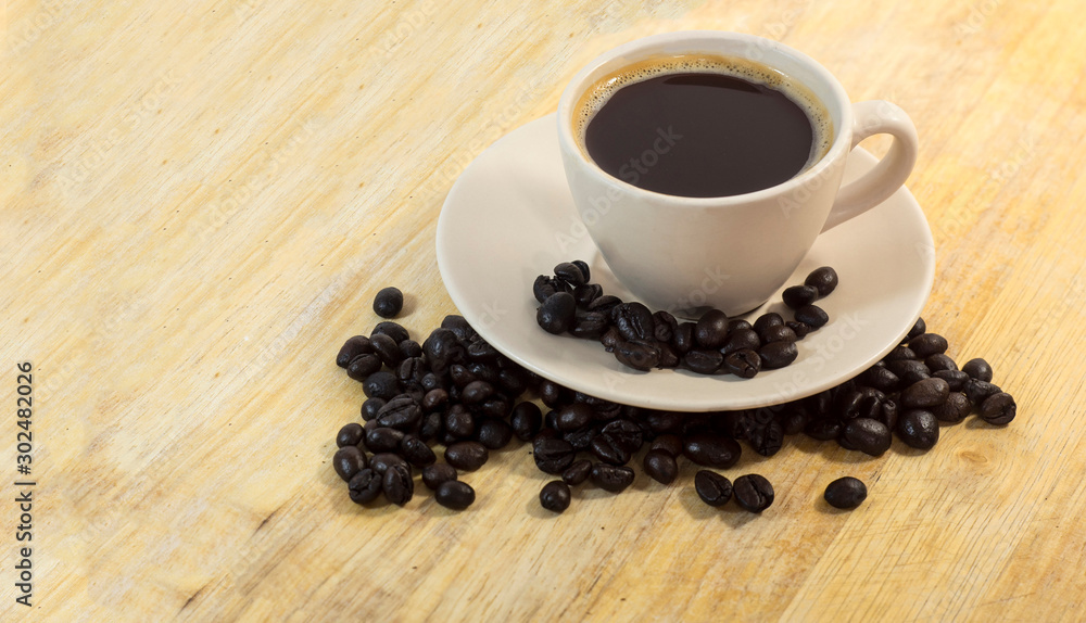 cup of coffee and beans on wooden table cup of coffee and beans on wooden table