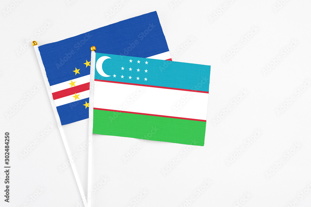 Uzbekistan and Cape Verde stick flags on white background. High quality fabric, miniature national flag. Peaceful global concept.White floor for copy space. Uzbekistan and Cape Verde stick flags on white background. High quality fabric, miniature national flag. Peaceful global concept.White floor for copy space.