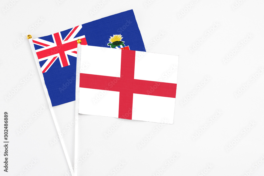England and Cayman Islands stick flags on white background. High quality fabric, miniature national flag. Peaceful global concept.White floor for copy space.