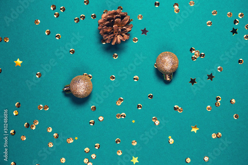 Golden decorative balls, cone and sequins on bright background. Christmas backdrop. Celebration and party concept.