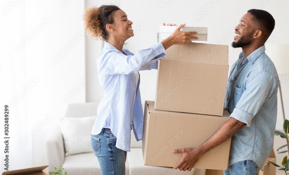 African American Couple Carrying Out Boxes Leaving Old Apartment African American Couple Carrying Out Boxes Leaving Old Apartment