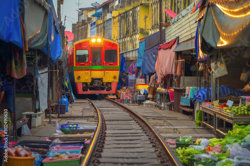 Rom Hoop market. Thai Railway with a local train run through Mae Klong Market in Samut Songkhram Province, Thailand. Tourist attraction in travel and transportation concept. photo